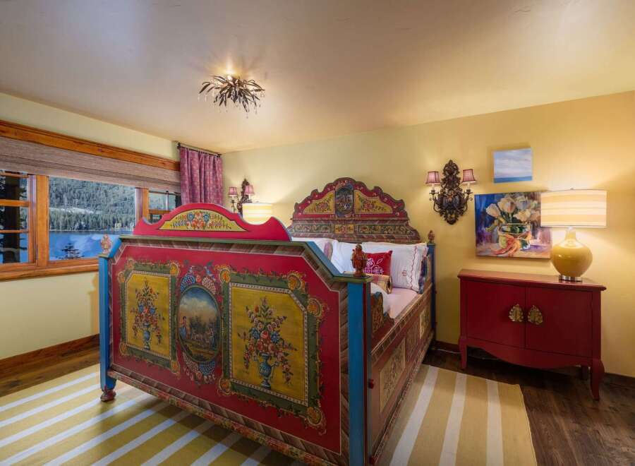This charming bedroom features a unique, hand-painted bed frame, adding a touch of artistic flair to the space.