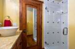 Step into luxury with this stunning bathroom featuring a custom wooden door with a built-in mirror.