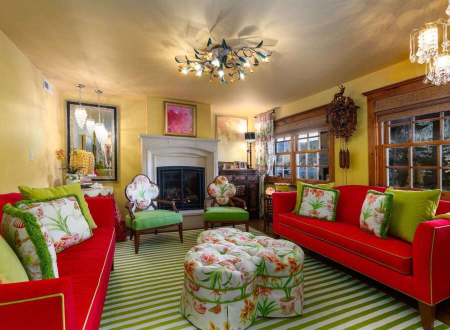 Step into a vibrant living space with a bold red sofa and matching chairs, complemented by a striking green and white striped rug.