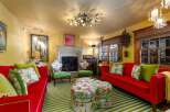 Step into a vibrant living space with a bold red sofa and matching chairs, complemented by a striking green and white striped rug.