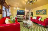 Step into a vibrant living space with this stunning property, featuring a bold red sofa and a matching ottoman, creating a focal point of style.
