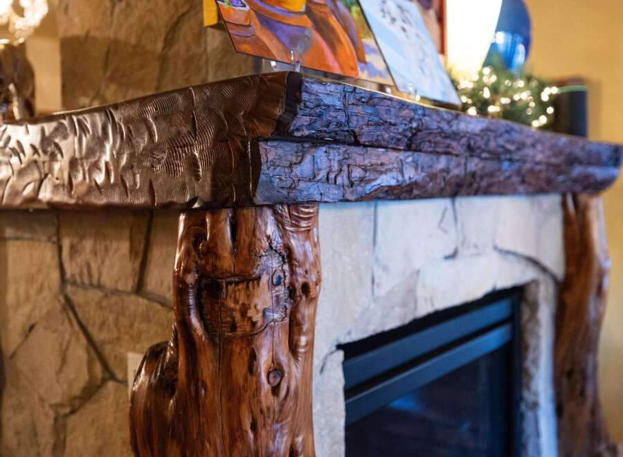 This stunning fireplace is a focal point in any home, featuring a unique wooden mantel that adds rustic charm.