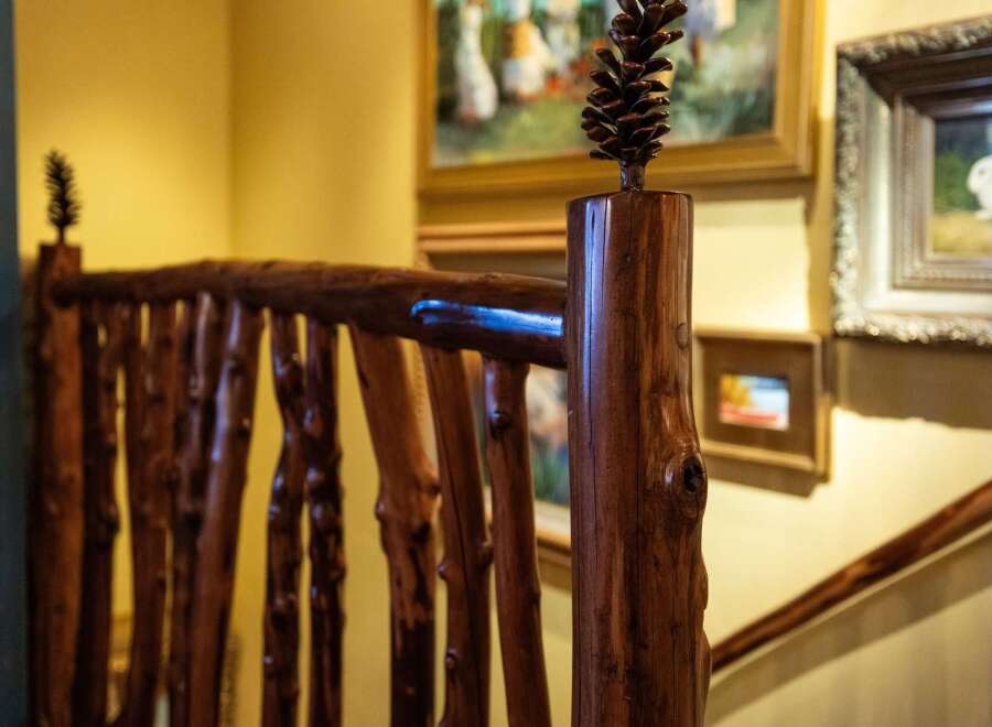 This stunning property boasts a unique rustic design, featuring a beautifully crafted wooden railing.