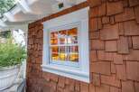 This charming property boasts a unique architectural design, featuring a beautiful window with a white frame and a warm, inviting interior.