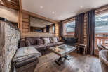 Experience luxurious mountain living in this stunning chalet-style living room, featuring a plush sectional sofa and a unique glass-top coffee table.