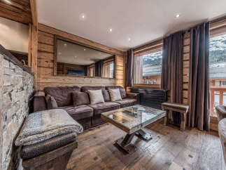 Experience luxurious mountain living in this stunning chalet-style living room, featuring a plush sectional sofa and a unique glass-top coffee table.