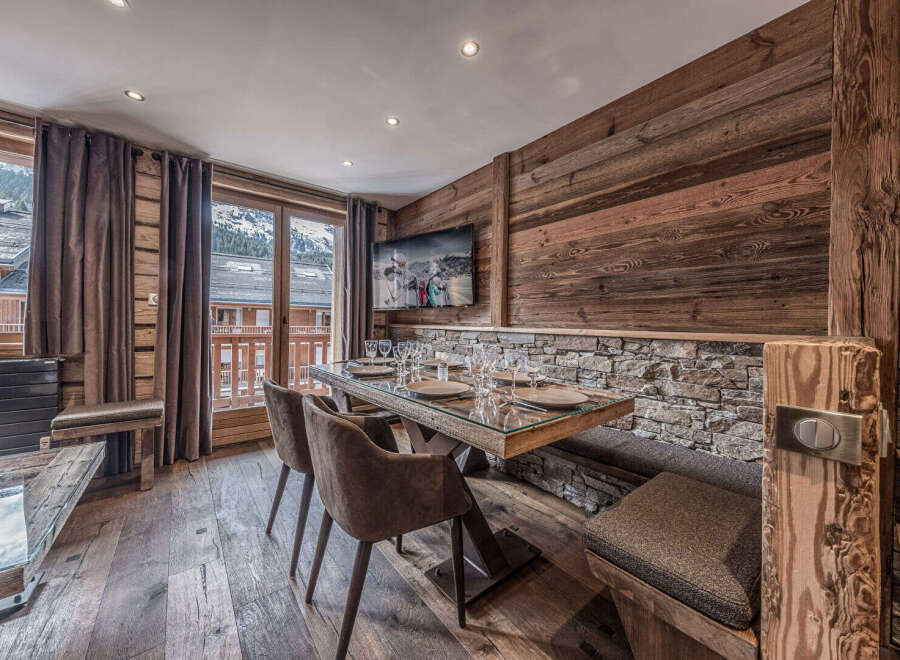 Experience rustic charm and modern comfort in this dining area, featuring a stunning glass-top table with a live-edge wood base, complemented by plush upholstered chairs and a built-in banquette.