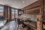 Experience rustic charm and modern comfort in this dining area, featuring a stunning glass-top table with a live-edge wood base, complemented by plush upholstered chairs and a built-in banquette.