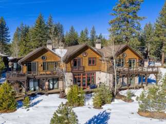 Nestled amidst a serene, snow-covered landscape, this stunning property boasts a blend of rustic charm and modern elegance.