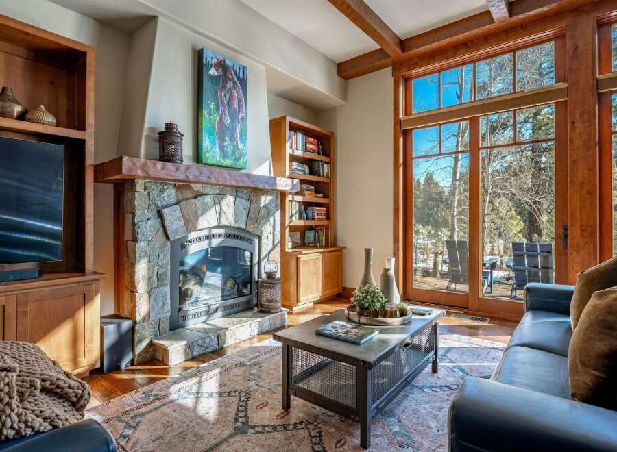 Experience the warmth of this stunning living room, featuring a cozy fireplace and elegant wooden accents.