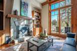 Experience the warmth of this stunning living room, featuring a cozy stone fireplace and a beautiful wooden bookshelf.