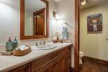 This charming bathroom features a warm, inviting ambiance with its wooden cabinetry and a large mirror.