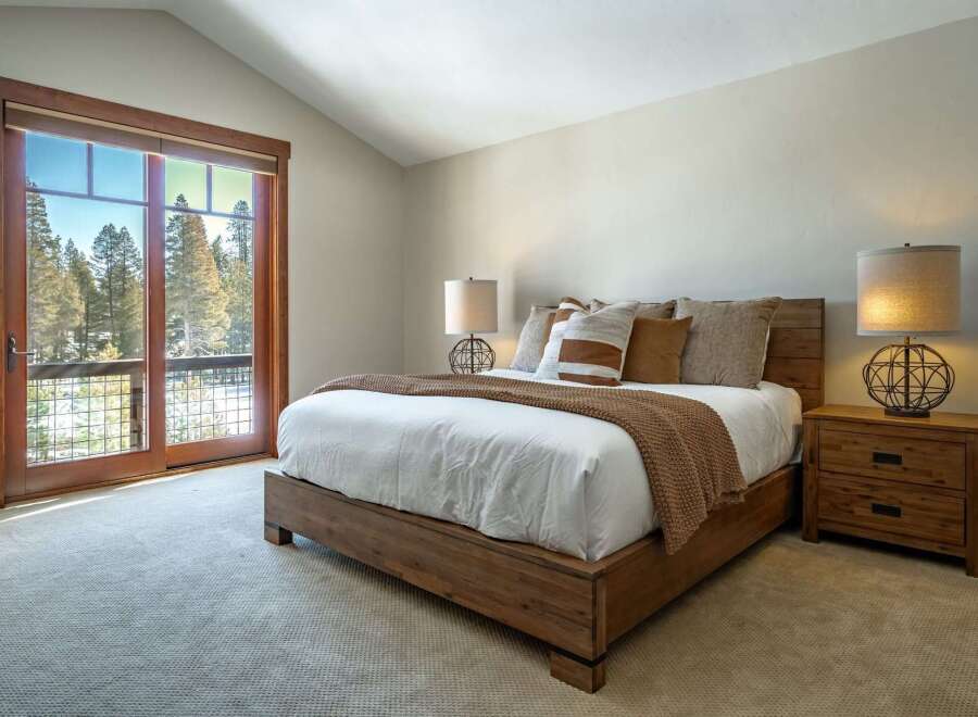 Experience the tranquility of this stunning bedroom, featuring a cozy bed and a warm, inviting atmosphere.