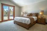 Experience the tranquility of this stunning bedroom, featuring a cozy bed and a warm, inviting atmosphere.