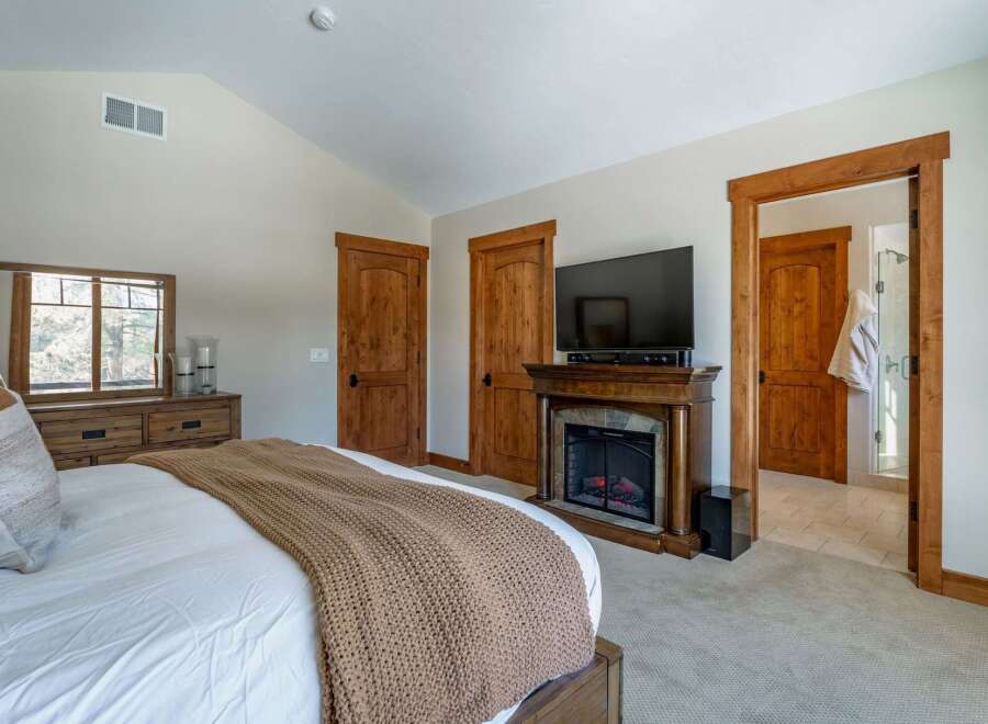 This luxurious bedroom features a cozy fireplace, perfect for relaxing on chilly evenings.