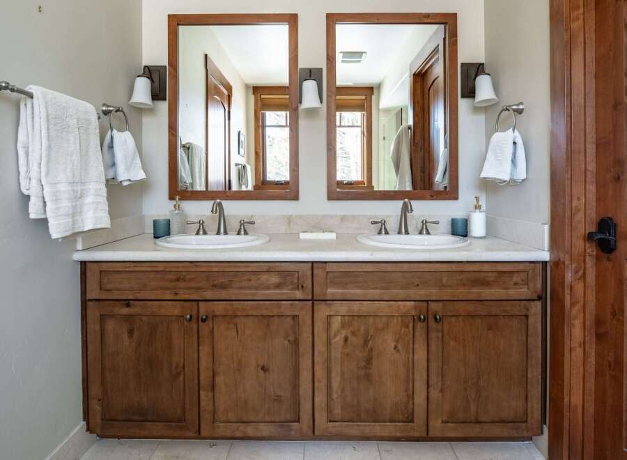 This stunning bathroom features a double vanity with a beautiful wooden cabinet, offering ample storage space.