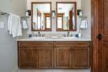This stunning bathroom features a double vanity with a beautiful wooden cabinet, offering ample storage space.