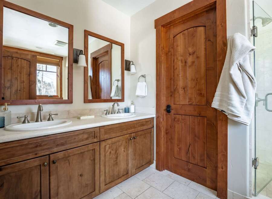 This stunning bathroom features a beautiful wooden vanity with dual sinks, offering ample space and storage.