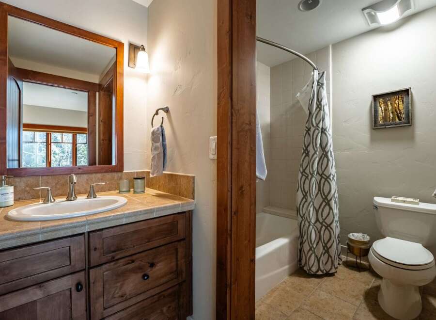 This beautiful bathroom features a stylish vanity with a large mirror and ample storage.