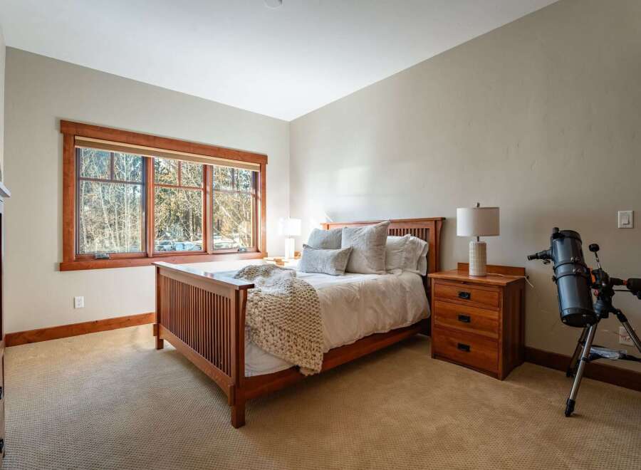 This inviting bedroom features a cozy bed with plush pillows and a warm, inviting throw.