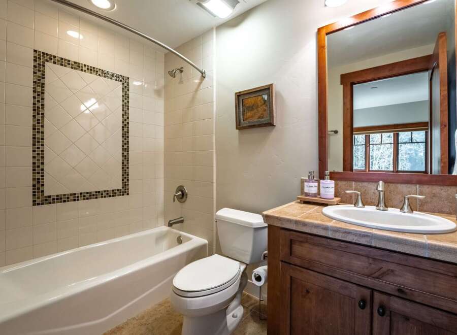 This beautiful bathroom features a modern design with a sleek white bathtub and a stylish vanity.