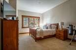 This inviting bedroom features a cozy ambiance with a wooden bed frame and matching nightstands.