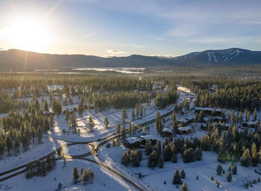 Discover a stunning winter wonderland property nestled amidst snow-covered trees and majestic mountains.