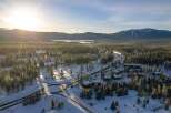 Discover a stunning winter wonderland property nestled amidst snow-covered trees and majestic mountains.