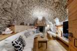 Step into rustic elegance with this stunning property, featuring a unique stone-walled interior and a cozy fireplace.