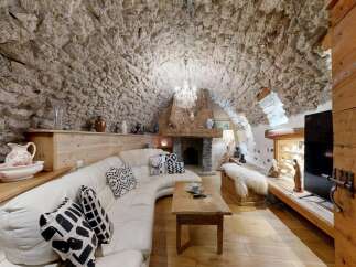Step into rustic elegance with this stunning property, featuring a unique stone-walled interior and a cozy fireplace.