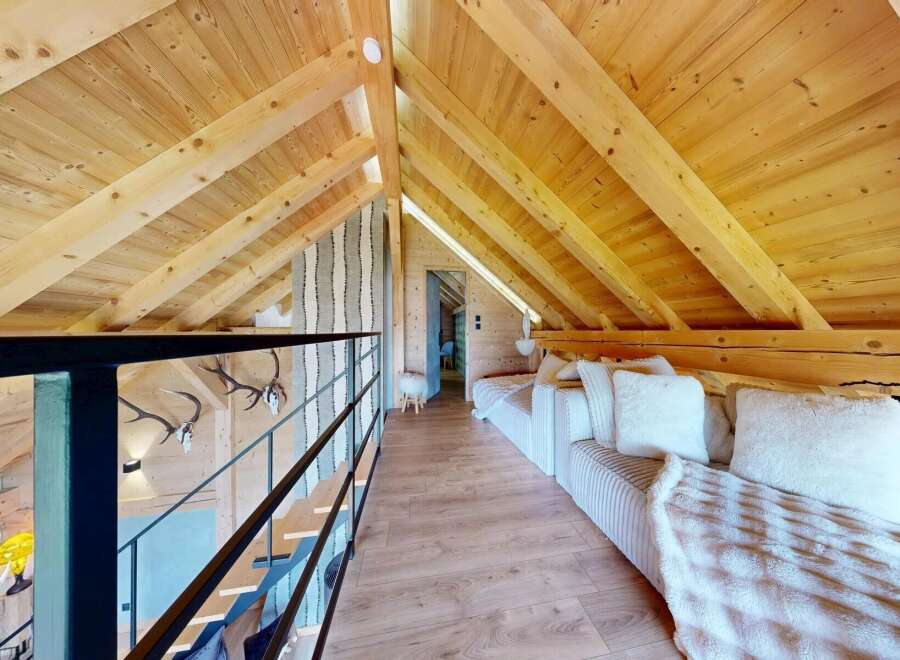 Discover the charm of this stunning loft space, featuring a warm wooden interior and a cozy seating area perfect for relaxation.