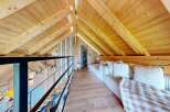 Discover the charm of this stunning loft space, featuring a warm wooden interior and a cozy seating area perfect for relaxation.