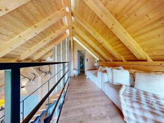 Discover the charm of this stunning loft space, featuring a warm wooden interior and a cozy seating area perfect for relaxation.