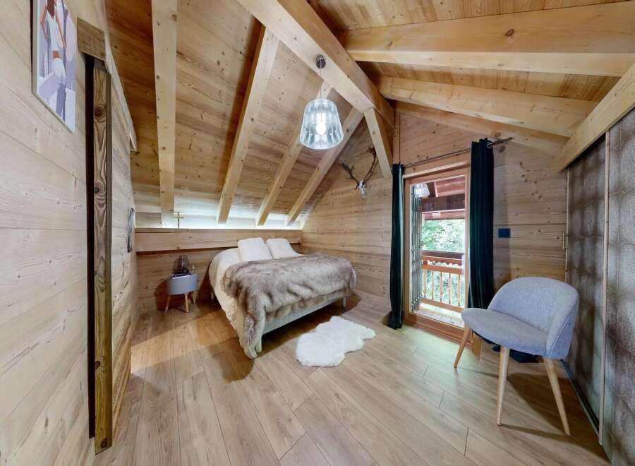 Experience the charm of this cozy bedroom, featuring a rustic wooden interior and a comfortable bed.