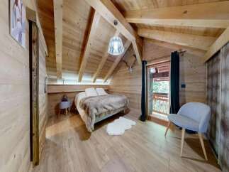 Experience the charm of this cozy bedroom, featuring a rustic wooden interior and a comfortable bed.