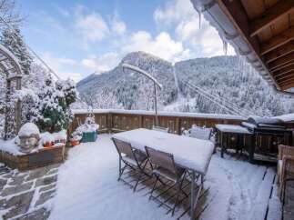 Experience the magic of winter from this stunning property's deck, offering breathtaking panoramic views of snow-covered mountains and lush pine forests.