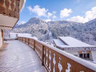 Experience the ultimate winter getaway from this charming balcony overlooking a snow-covered mountain landscape.
