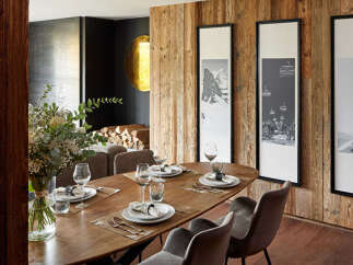 Experience luxury living in this stunning dining room, featuring a beautiful wooden table and stylish chairs.