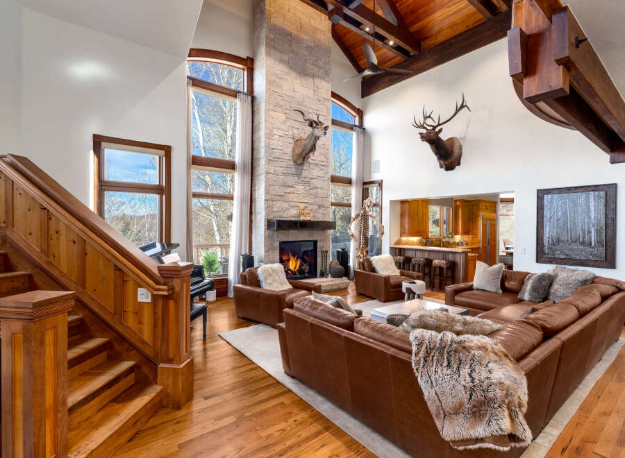 Step into luxury with this stunning property featuring a grand living room with a stone fireplace and soaring ceilings.