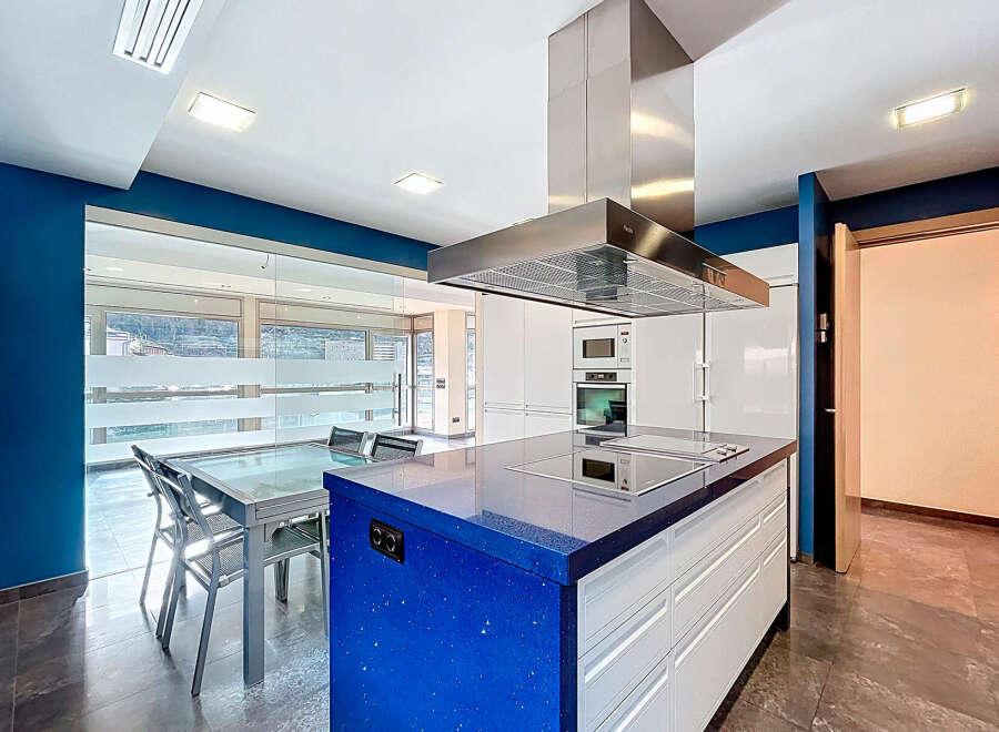 This modern kitchen boasts a stunning blue countertop island, perfect for meal preparation and entertaining.