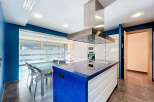 This modern kitchen boasts a stunning blue countertop island, perfect for meal preparation and entertaining.