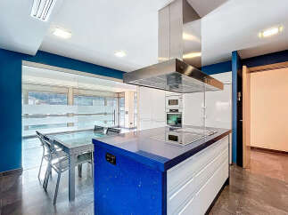 This modern kitchen boasts a stunning blue countertop island, perfect for meal preparation and entertaining.