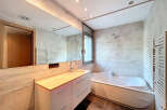 This modern bathroom boasts a sleek design with a spacious vanity and a luxurious bathtub.