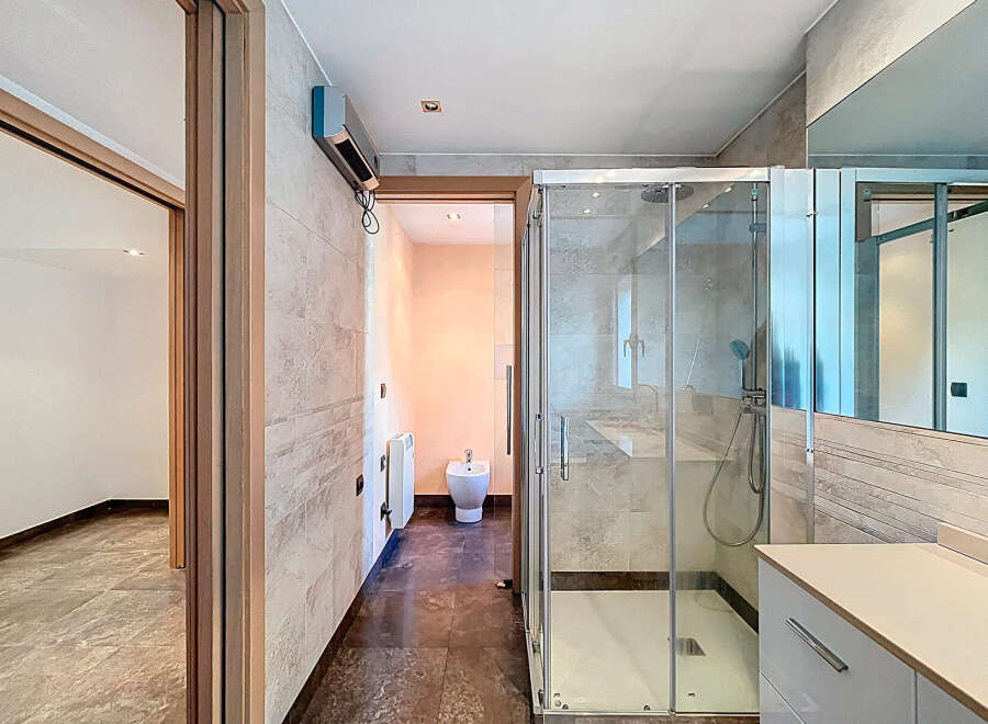 Step into this modern bathroom, featuring a sleek glass shower enclosure and contemporary design.