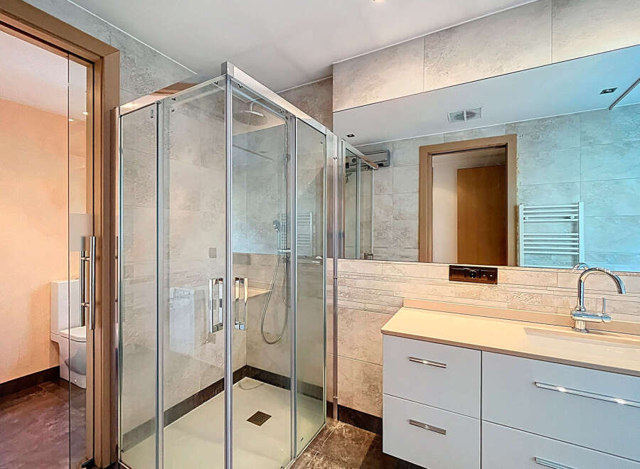 Step into luxury with this stunning bathroom! Featuring a modern glass shower, sleek white cabinetry, and a large mirror, this space is designed for both style and functionality.