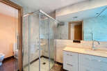 Step into luxury with this stunning bathroom! Featuring a modern glass shower, sleek white cabinetry, and a large mirror, this space is designed for both style and functionality.