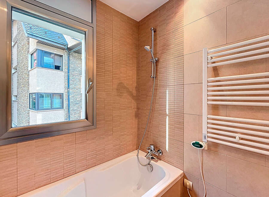This bathroom features a modern design with a sleek bathtub and a stylish showerhead.