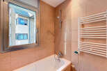 This bathroom features a modern design with a sleek bathtub and a stylish showerhead.