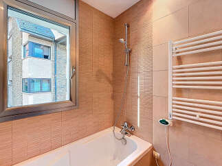 This bathroom features a modern design with a sleek bathtub and a stylish showerhead.