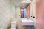 This modern bathroom features a sleek, minimalist design with a large mirror and a stylish sink.